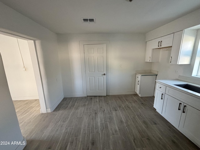 kitchen with white cabinets, sink, and hardwood / wood-style floors