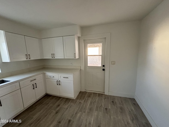 kitchen with white cabinetry, sink, and dark wood-type flooring