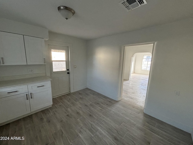 kitchen with light wood-type flooring and white cabinetry