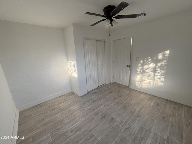 unfurnished bedroom with a closet, light hardwood / wood-style flooring, and ceiling fan