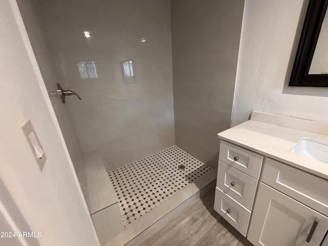 bathroom featuring a tile shower, vanity, and hardwood / wood-style flooring