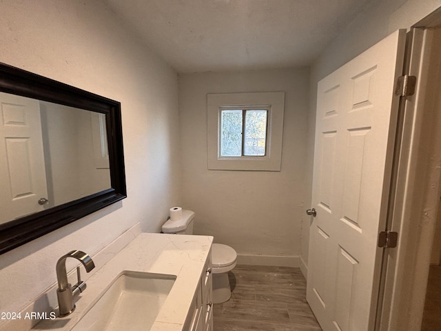 bathroom featuring toilet, vanity, and hardwood / wood-style flooring