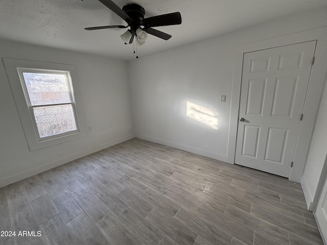 empty room featuring ceiling fan and light hardwood / wood-style flooring