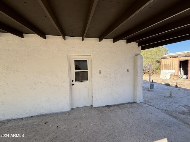 view of exterior entry with a patio area