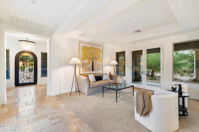 foyer entrance featuring a raised ceiling, visible vents, and stone tile floors