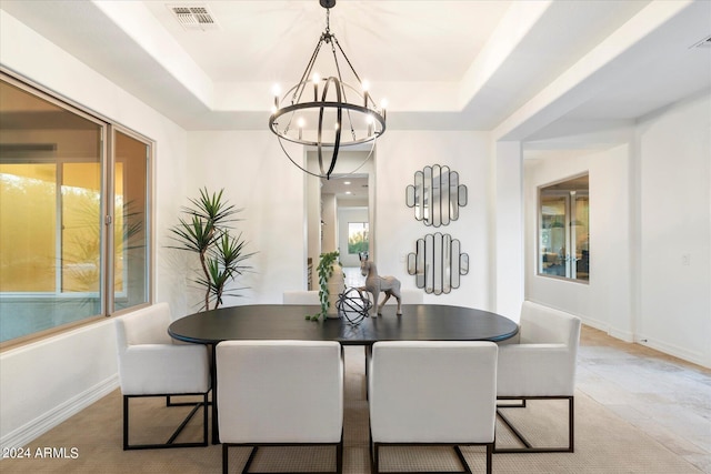 dining room with a chandelier, a raised ceiling, visible vents, and baseboards