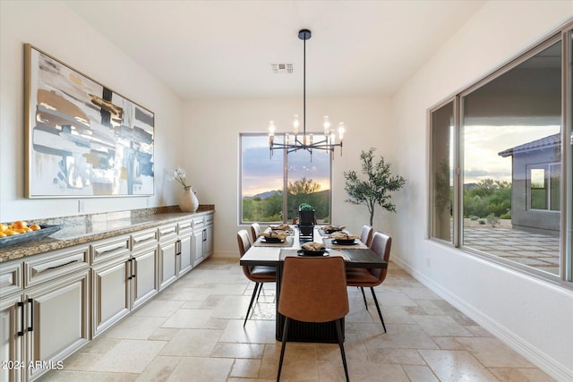 dining space with a wealth of natural light, baseboards, visible vents, and stone tile flooring