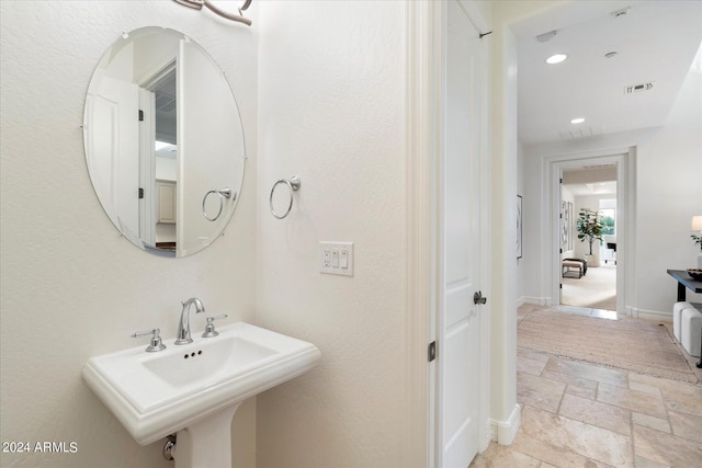 bathroom with recessed lighting, a sink, visible vents, baseboards, and stone tile flooring