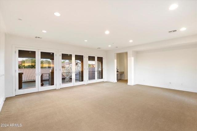 spare room featuring light colored carpet, visible vents, and recessed lighting