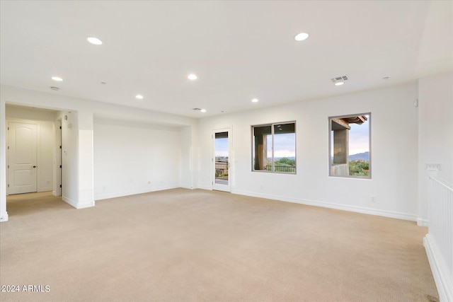 empty room featuring recessed lighting, light carpet, visible vents, and baseboards