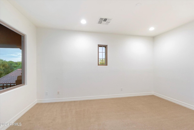 unfurnished room with light colored carpet, visible vents, baseboards, and recessed lighting