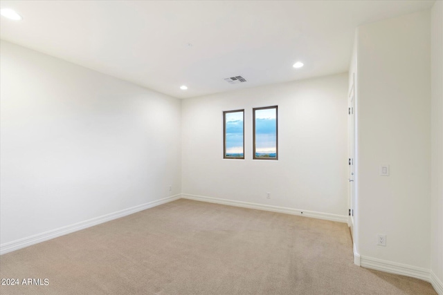 spare room featuring baseboards, light colored carpet, visible vents, and recessed lighting