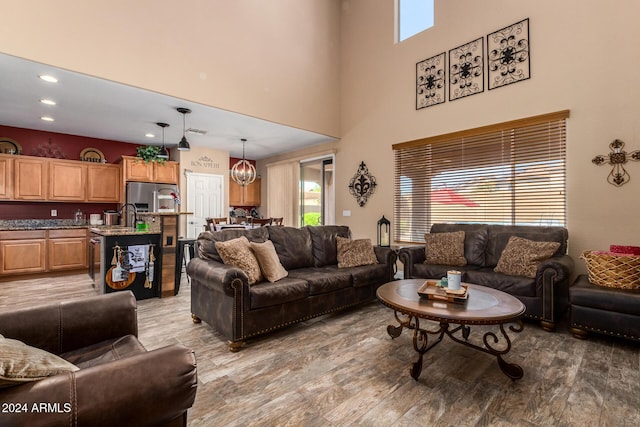 6084 W Yorktown Way, Florence, AZ 85132 - living area featuring a towering ceiling, recessed lighting, and light wood-type flooring