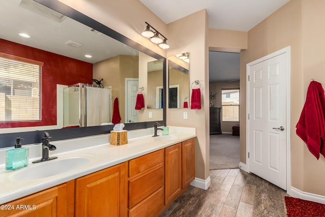 6084 W Yorktown Way, Florence, AZ 85132 - full bath featuring a sink, baseboards, double vanity, and wood finished floors
