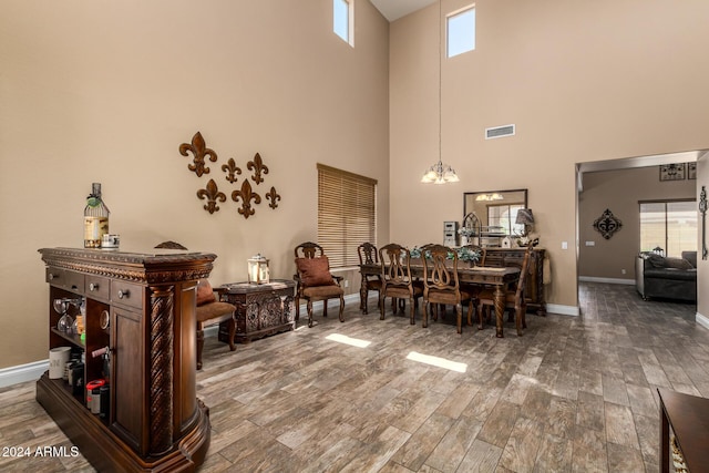 6084 W Yorktown Way, Florence, AZ 85132 - dining room with a high ceiling, a notable chandelier, baseboards, wood finished floors, and visible vents