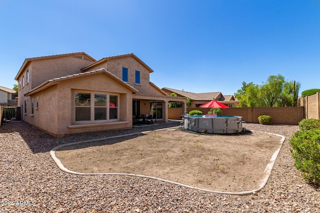 6084 W Yorktown Way, Florence, AZ 85132 - back of property featuring a fenced in pool, a fenced backyard, stucco siding, and a tile roof