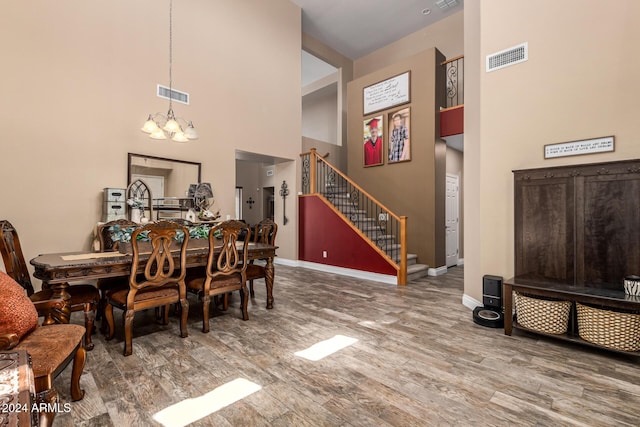 6084 W Yorktown Way, Florence, AZ 85132 - dining area featuring visible vents, wood finished floors, a high ceiling, stairway, and a chandelier