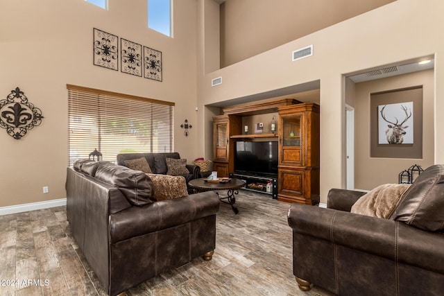 6084 W Yorktown Way, Florence, AZ 85132 - living area featuring a towering ceiling, baseboards, wood finished floors, and visible vents