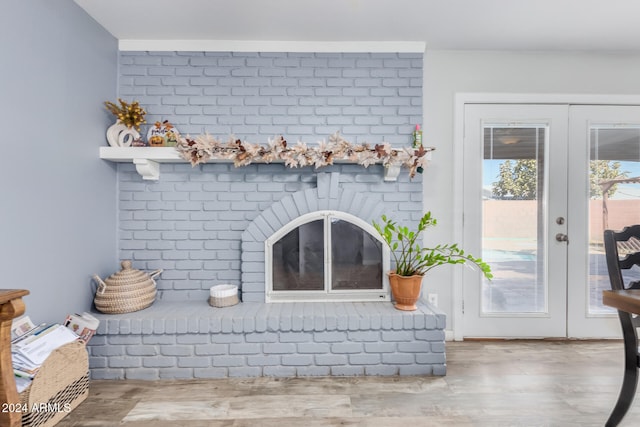 details featuring french doors, a brick fireplace, and hardwood / wood-style floors