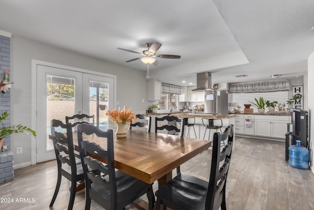 dining room featuring ceiling fan, french doors, and light hardwood / wood-style flooring