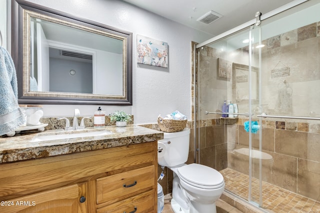 bathroom with walk in shower, vanity, and toilet