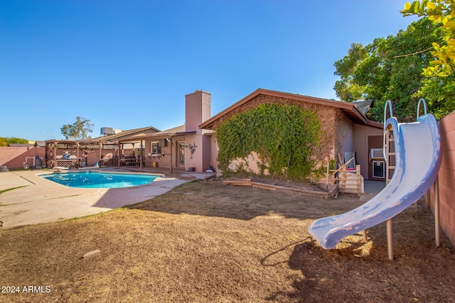 view of swimming pool with a patio and a water slide