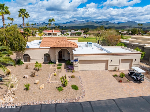 mediterranean / spanish-style house with a garage and a mountain view