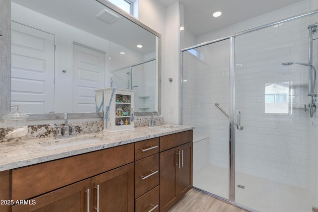 bathroom with hardwood / wood-style floors, vanity, and walk in shower