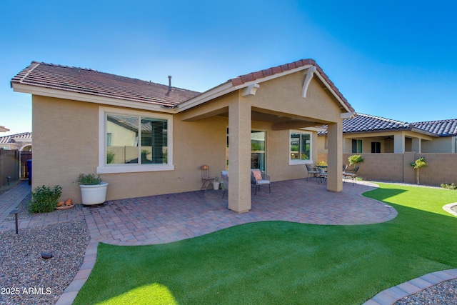 back of house featuring a lawn and a patio