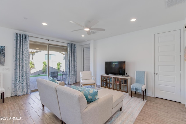 living room with ceiling fan and light hardwood / wood-style flooring