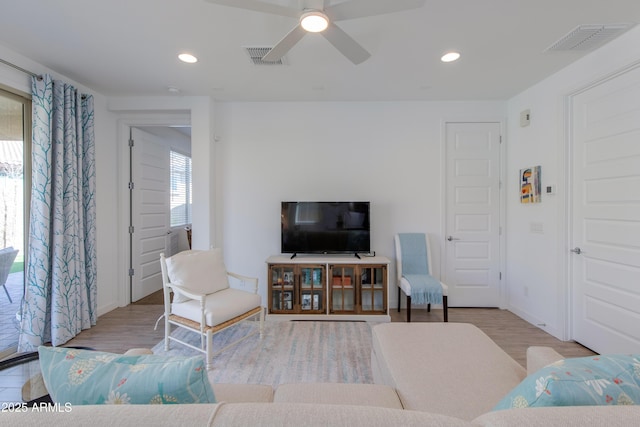 living room with light hardwood / wood-style floors and ceiling fan