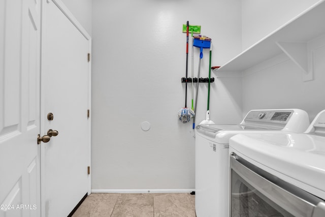 laundry room featuring light tile patterned flooring and washing machine and clothes dryer