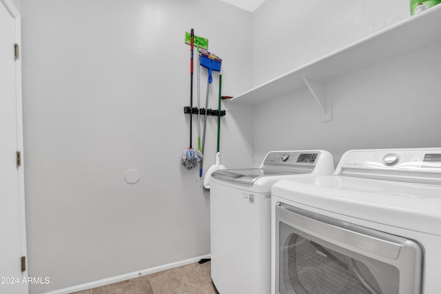 laundry area with light tile patterned flooring and washing machine and dryer