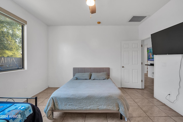 tiled bedroom featuring ceiling fan