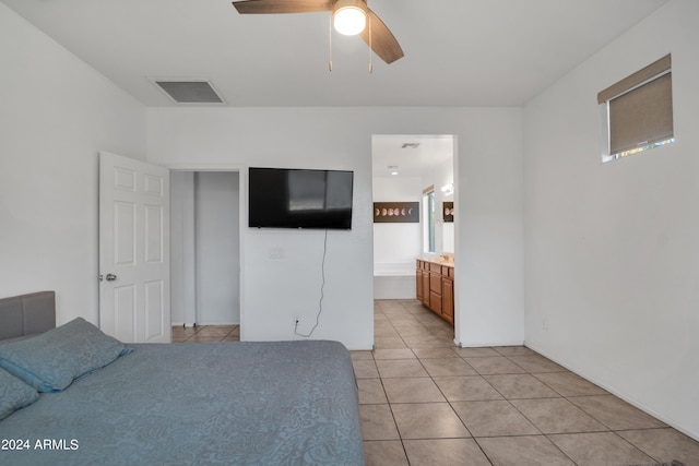 unfurnished bedroom featuring ensuite bath, light tile patterned floors, and ceiling fan