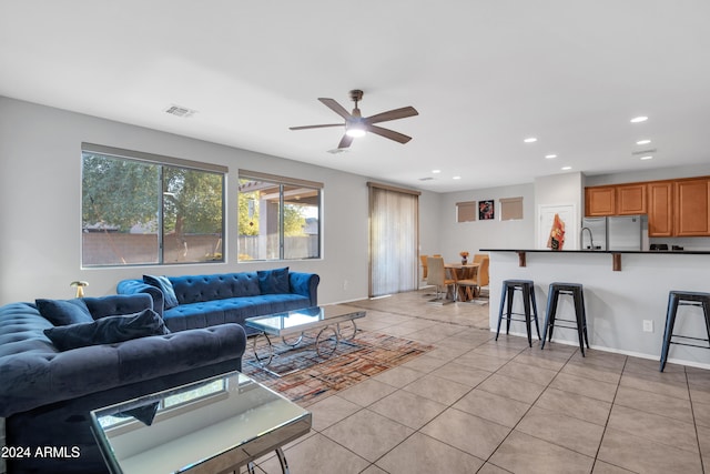 tiled living room with ceiling fan