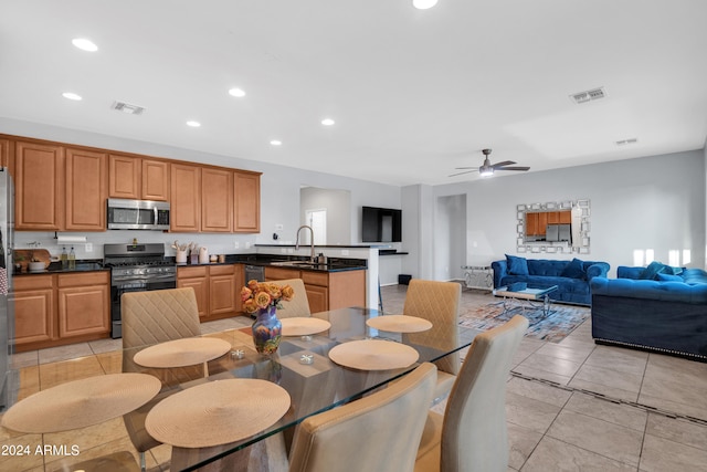 tiled dining area featuring ceiling fan and sink