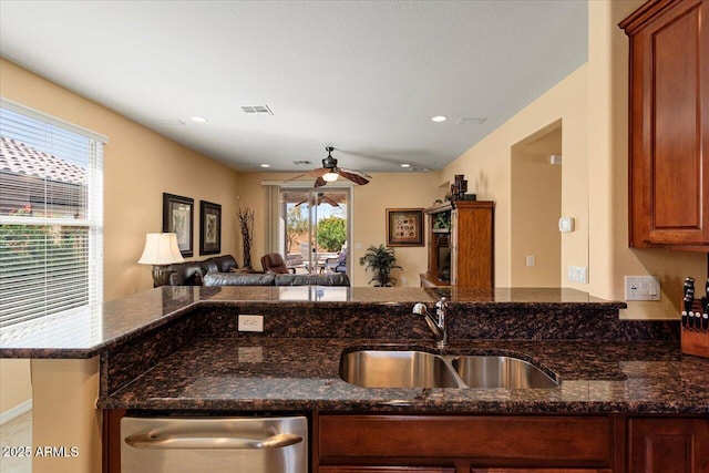 kitchen with visible vents, dark stone counters, open floor plan, and a sink