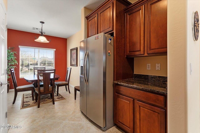 kitchen with dark stone countertops, baseboards, hanging light fixtures, and stainless steel fridge with ice dispenser