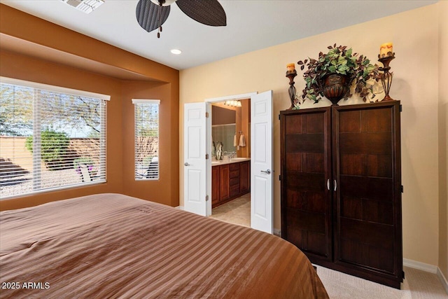 bedroom featuring ensuite bathroom, a ceiling fan, and baseboards