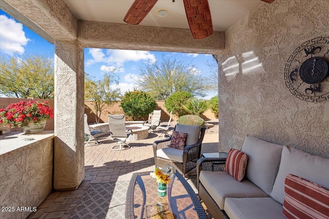 view of patio with an outdoor living space with a fire pit and a fenced backyard