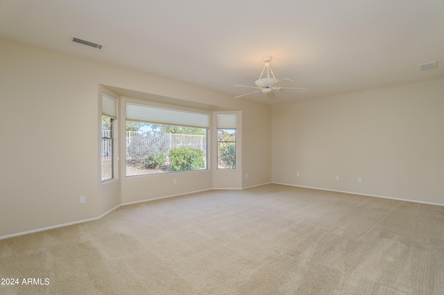 spare room featuring light carpet and ceiling fan