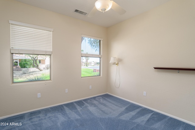 carpeted spare room featuring ceiling fan