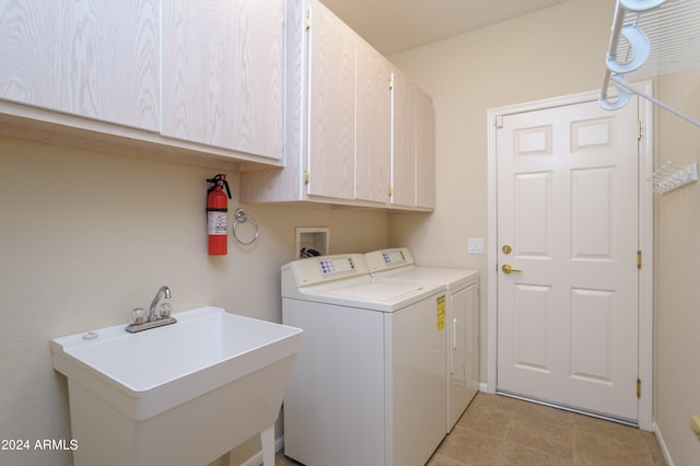 laundry room with washer and clothes dryer, sink, and cabinets