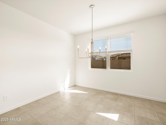 spare room with an inviting chandelier and light tile patterned flooring