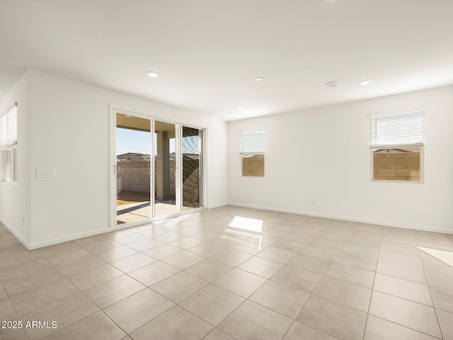 empty room featuring plenty of natural light and light tile patterned floors