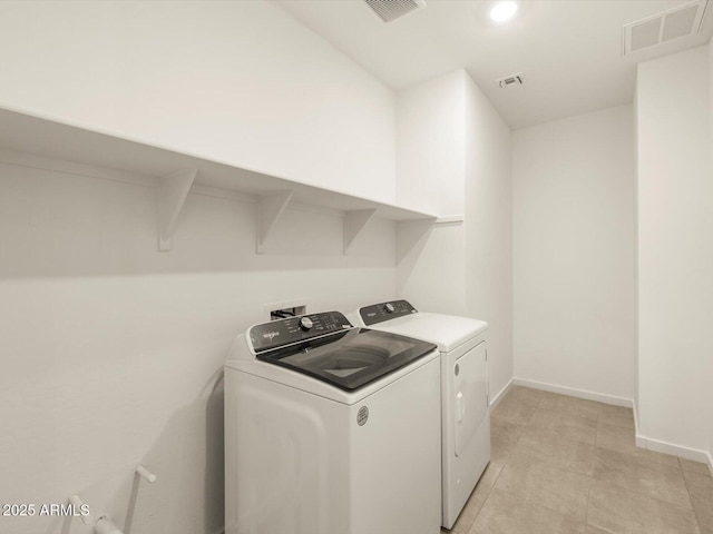 laundry room featuring light tile patterned flooring and separate washer and dryer