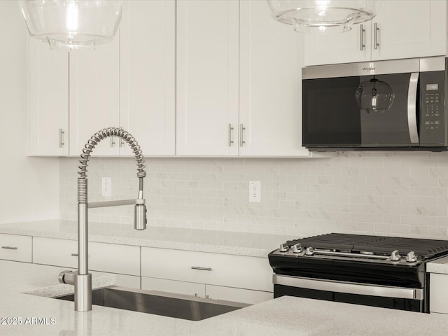 kitchen featuring white cabinetry, tasteful backsplash, sink, and range with gas cooktop