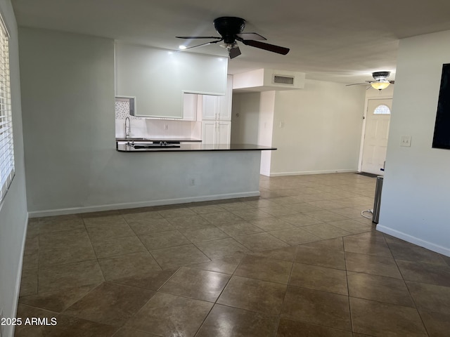 tiled spare room featuring ceiling fan