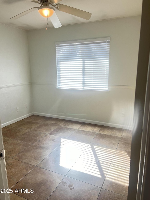 spare room with tile patterned floors and ceiling fan